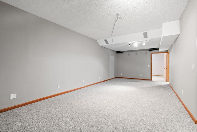 empty room featuring a textured ceiling and carpet