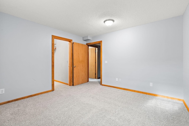 carpeted spare room with a textured ceiling