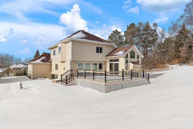 snow covered property featuring a wooden deck and central air condition unit