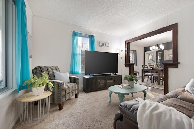 carpeted living room with a textured ceiling and a notable chandelier