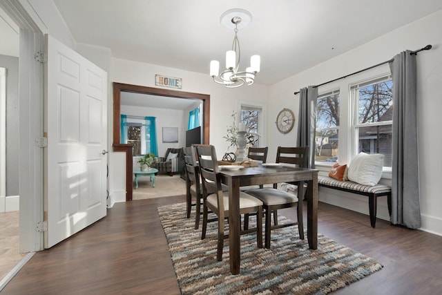 dining space with dark hardwood / wood-style flooring and a chandelier