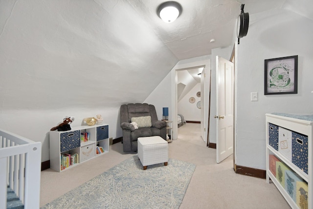 bedroom with a crib, light carpet, a textured ceiling, and vaulted ceiling