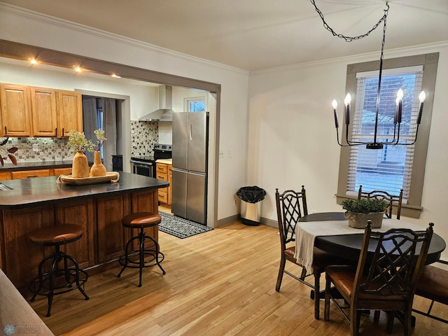 dining space featuring ornamental molding, light hardwood / wood-style floors, and an inviting chandelier