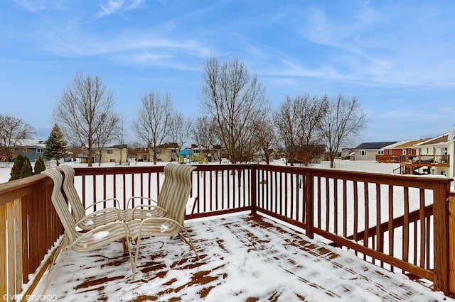 snow covered deck featuring a playground