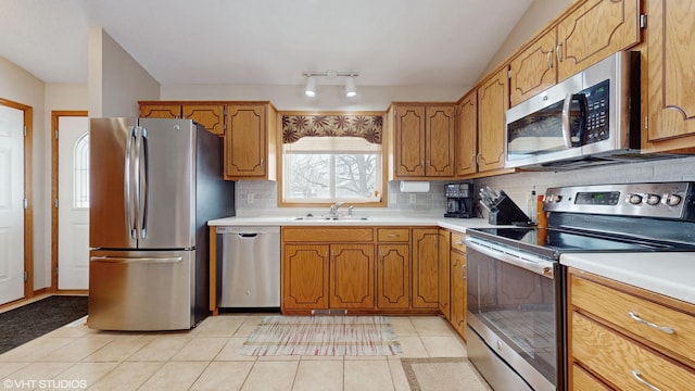 kitchen with decorative backsplash, sink, appliances with stainless steel finishes, and light tile patterned floors