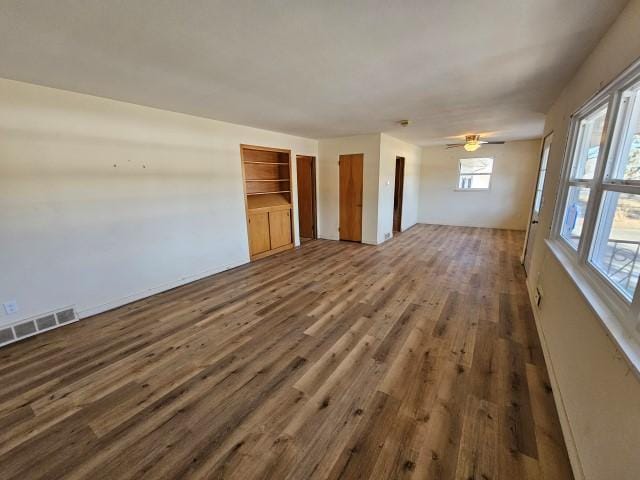 unfurnished living room featuring dark hardwood / wood-style floors, a healthy amount of sunlight, and ceiling fan