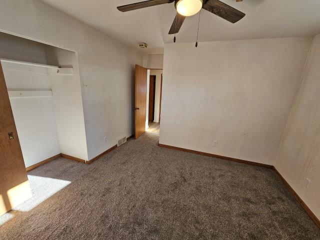 unfurnished bedroom featuring ceiling fan, carpet floors, and a closet