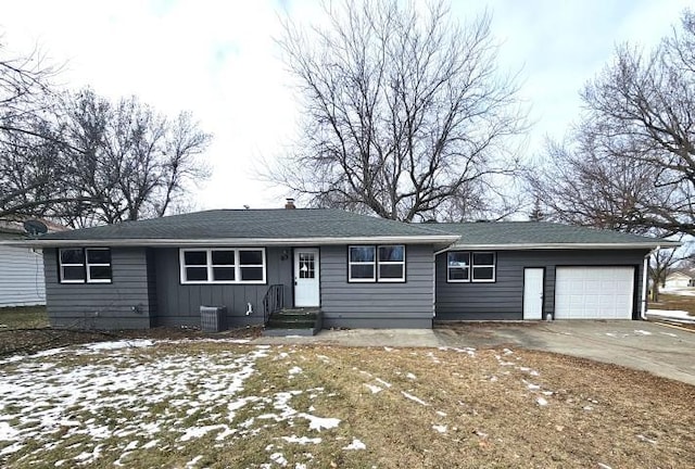 ranch-style house with central AC unit and a garage