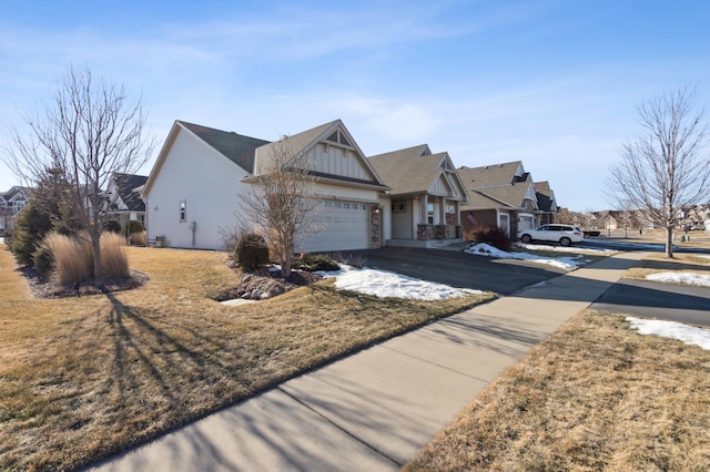 ranch-style home featuring a garage, driveway, a residential view, and board and batten siding