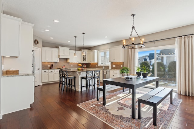 dining room with dark wood-style floors, recessed lighting, and an inviting chandelier