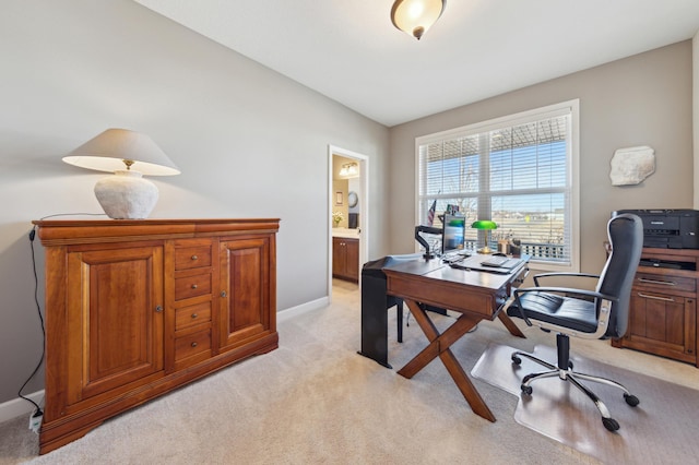 office area featuring light carpet and baseboards