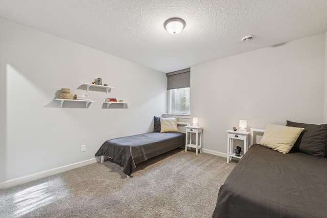 bedroom featuring light carpet, baseboards, and a textured ceiling