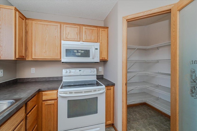 kitchen with a textured ceiling and white appliances