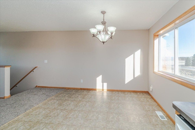 empty room featuring light carpet and an inviting chandelier