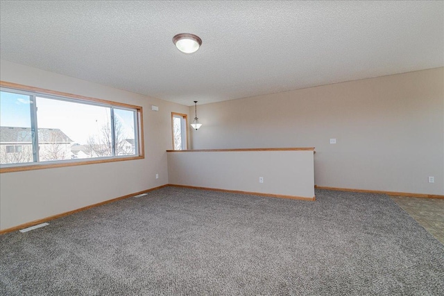 carpeted spare room featuring a textured ceiling