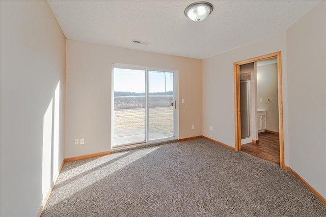 empty room with carpet and a textured ceiling