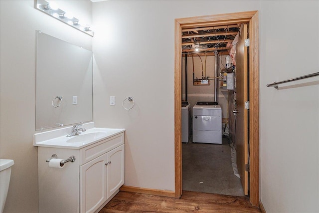 bathroom with vanity, hardwood / wood-style floors, independent washer and dryer, electric panel, and toilet