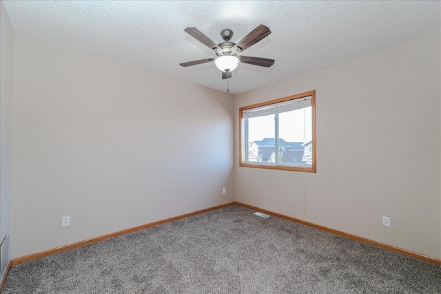 carpeted empty room featuring ceiling fan and a textured ceiling