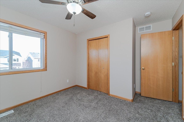 unfurnished bedroom with carpet, a textured ceiling, a closet, and ceiling fan