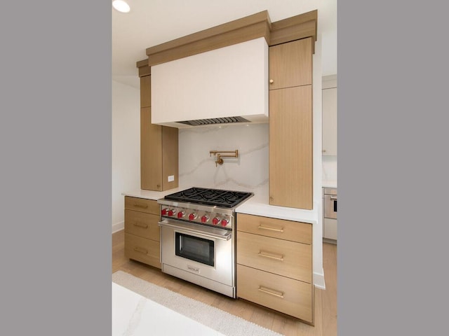 kitchen featuring modern cabinets, designer range, light countertops, light wood-style floors, and light brown cabinets