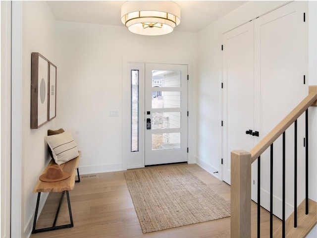 foyer featuring light wood-style floors and baseboards