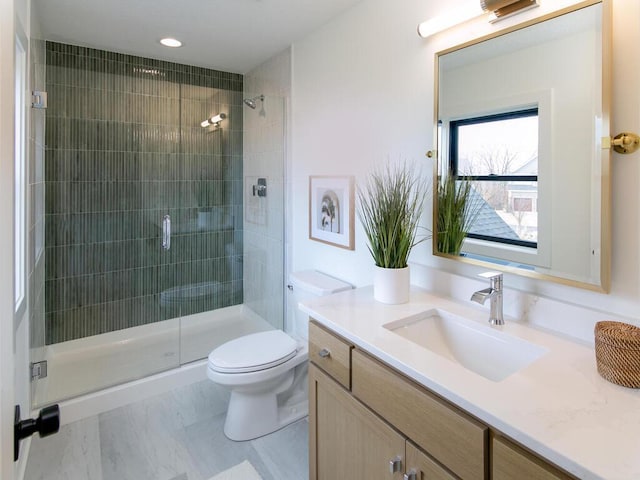 bathroom featuring toilet, a shower stall, and vanity