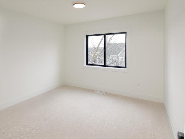 unfurnished room featuring baseboards, visible vents, and light colored carpet