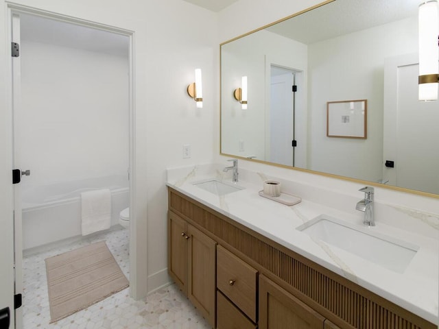 bathroom with toilet, double vanity, a sink, and tile patterned floors