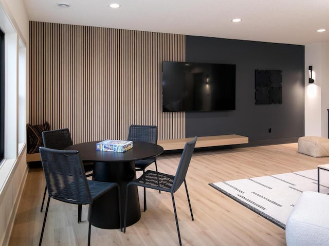 dining area with baseboards, an accent wall, wood finished floors, and recessed lighting