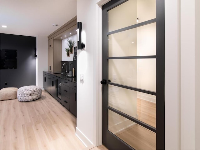 interior space with light wood finished floors, a sink, and recessed lighting