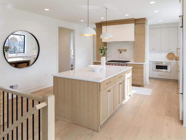 3447 Falcon Cir NW, Prior Lake, MN 55372 - kitchen featuring appliances with stainless steel finishes, light wood finished floors, a kitchen island, recessed lighting, and light brown cabinetry