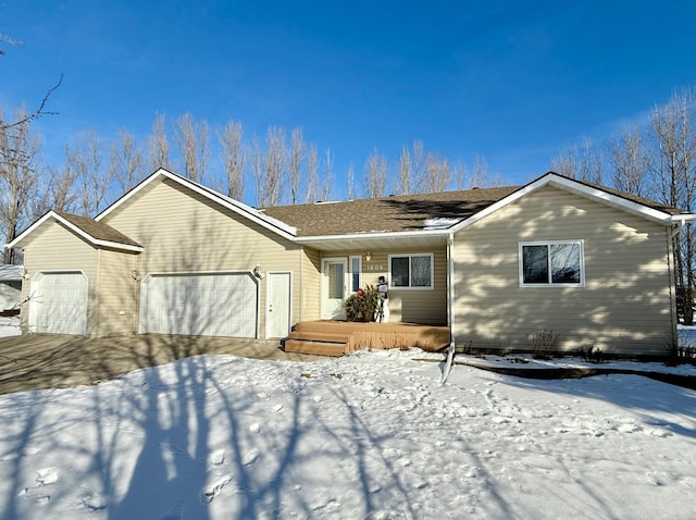 ranch-style home with a garage and a shingled roof