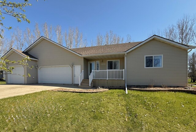 single story home featuring covered porch, an attached garage, a front lawn, and driveway
