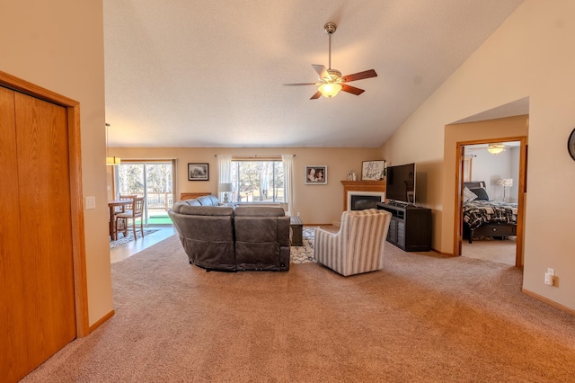 living area with ceiling fan, carpet floors, lofted ceiling, and a glass covered fireplace