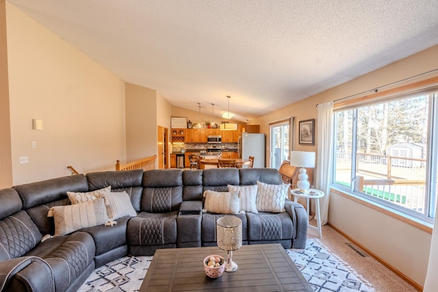 living room featuring vaulted ceiling, light carpet, baseboards, and a textured ceiling