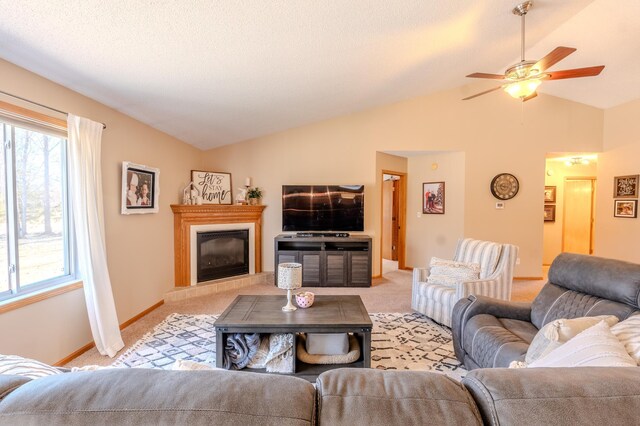 living area featuring light carpet, plenty of natural light, lofted ceiling, and a ceiling fan