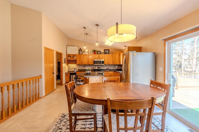 dining room with lofted ceiling and light tile patterned floors