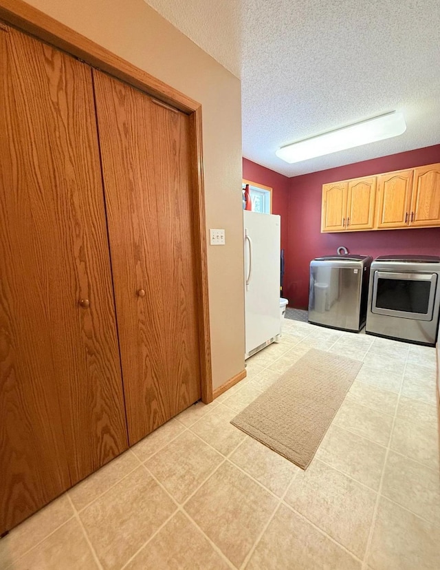 laundry room featuring cabinet space, independent washer and dryer, and a textured ceiling