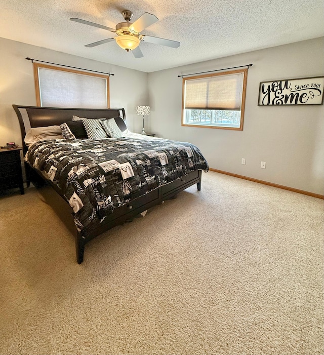 carpeted bedroom with baseboards, ceiling fan, and a textured ceiling