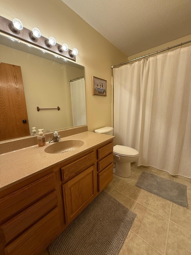 bathroom featuring tile patterned floors, vanity, a textured ceiling, and toilet