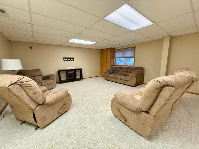 carpeted living area with a paneled ceiling and baseboards