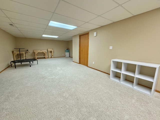 unfurnished room featuring a drop ceiling, carpet floors, and baseboards