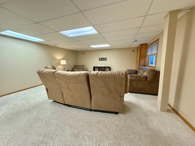 living room with carpet flooring, a drop ceiling, and baseboards
