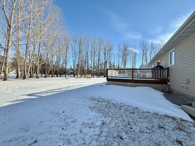yard layered in snow featuring a wooden deck