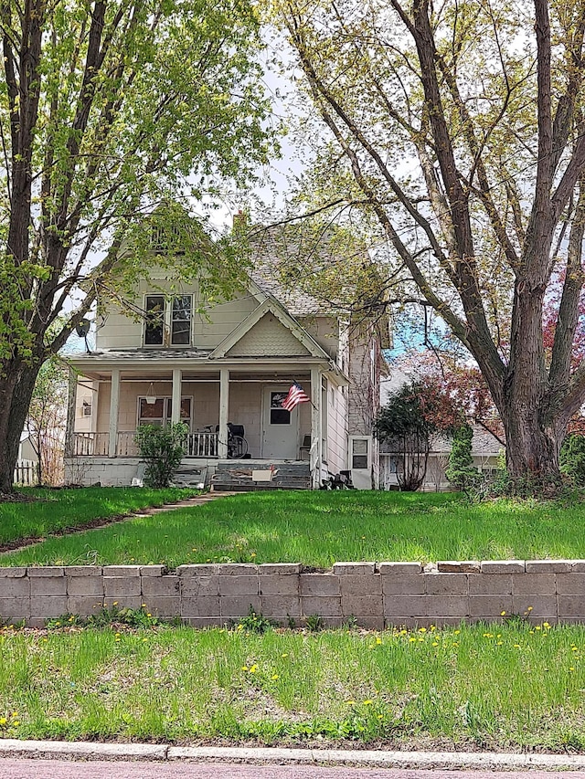 view of front of home with covered porch and a front yard