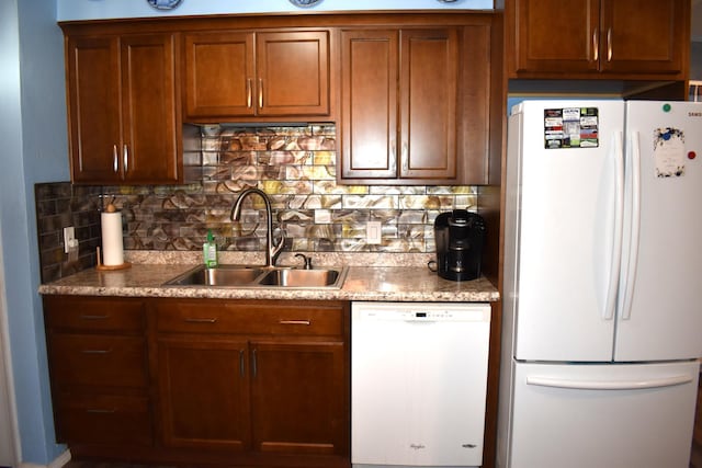 kitchen with decorative backsplash, white appliances, and sink