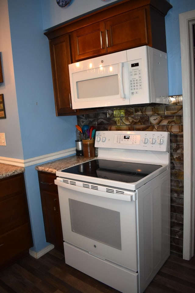 kitchen featuring white appliances and dark wood-type flooring