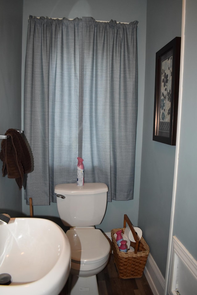 bathroom with toilet, wood-type flooring, and sink