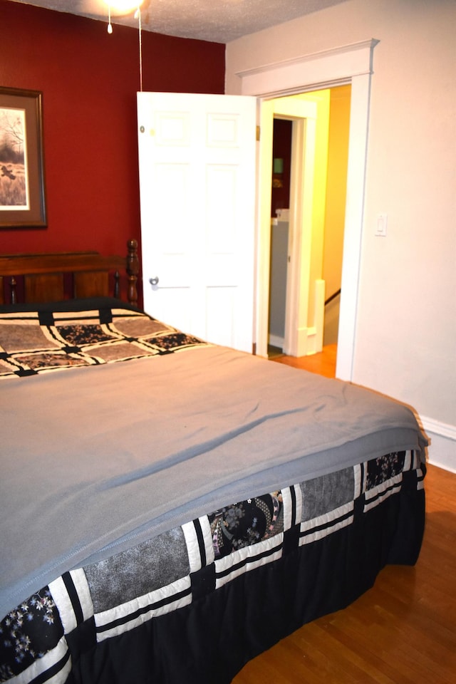 bedroom with hardwood / wood-style floors and a textured ceiling