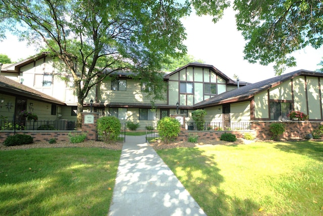 tudor home featuring a front yard and central AC